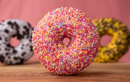 Doughnut With Sprinkles On Brown Wooden Table
